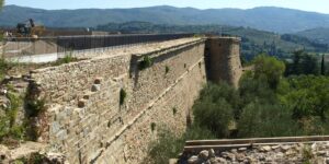 Restauro della Fortezza Medicea di Arezzo: mura in pietra restaurate con torrione e vista sulle colline